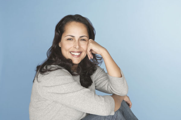 Hispanic woman smiling with head in hands